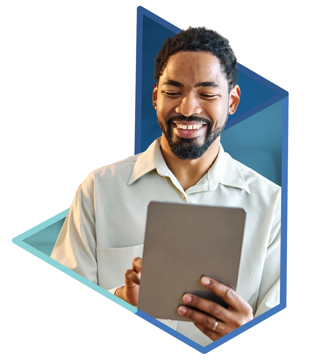 A smiling man with a beard looks down at a tablet he holds with both hands, wearing a light button-up shirt.